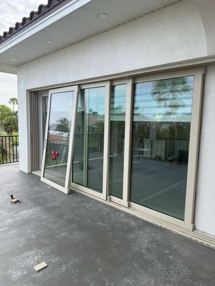 Multi-panel sliding glass door with newly replaced glass in a Tampa home