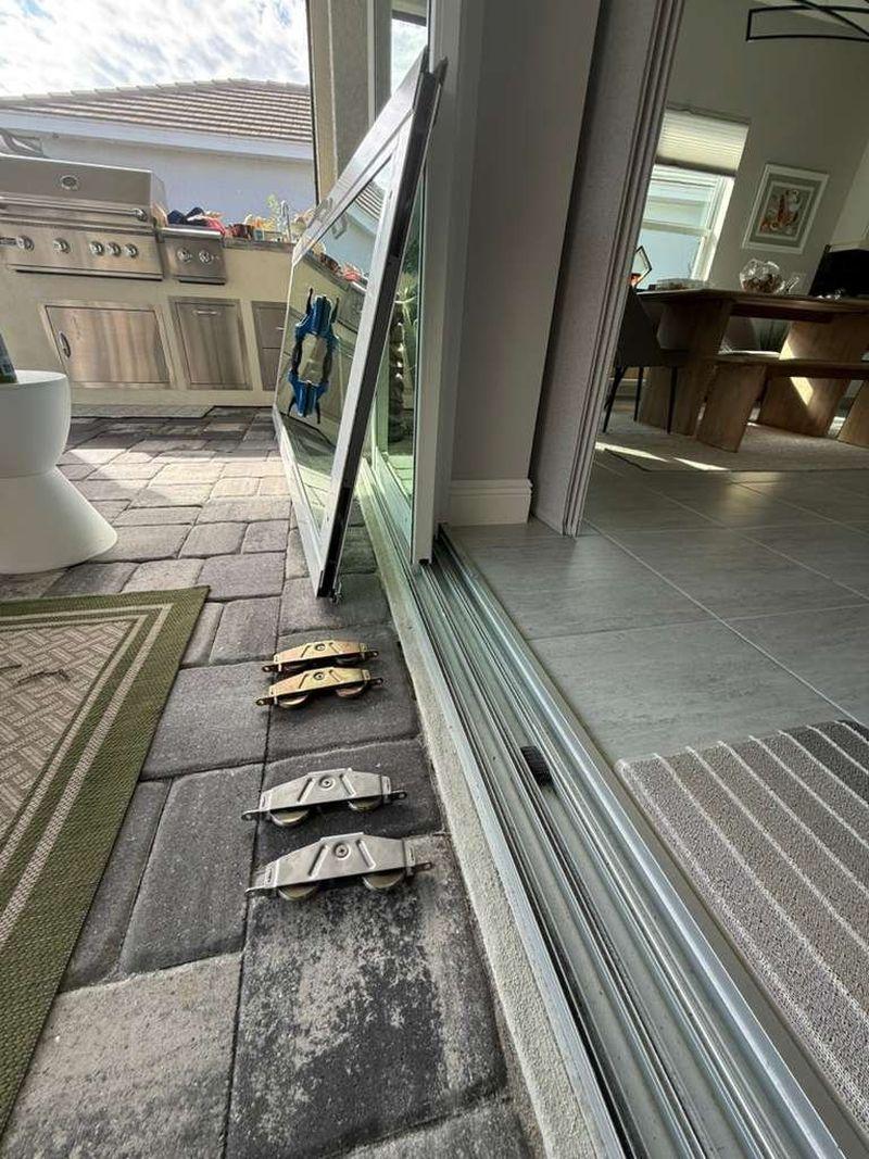 New sliding door rollers laid out beside the track during a Tampa repair